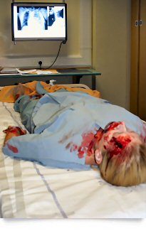 Patient lying down with x-ray and casualty make-up