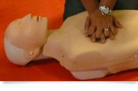 Person giving training doll CPR during lesson